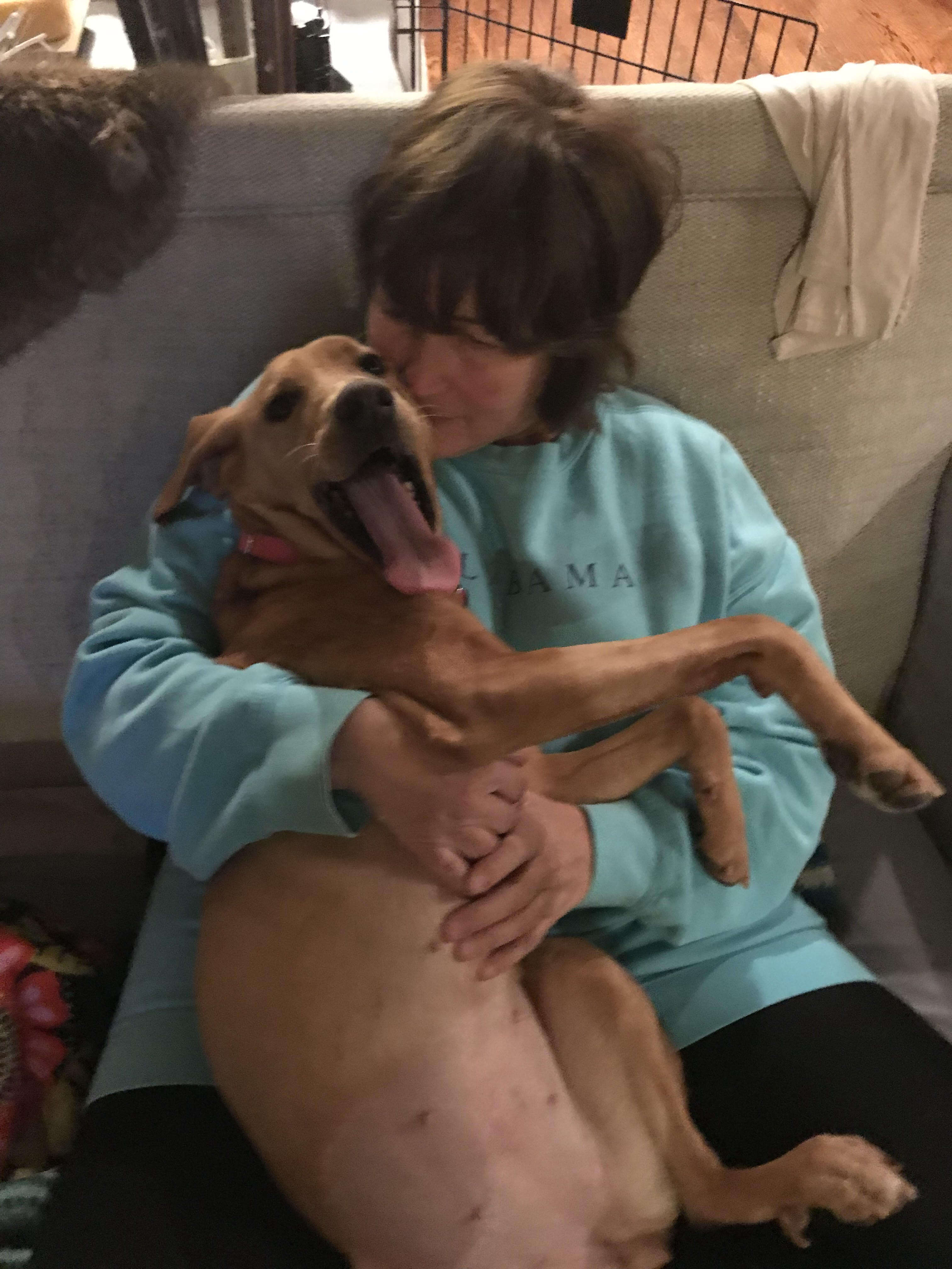 Woman cuddling happy looking dog