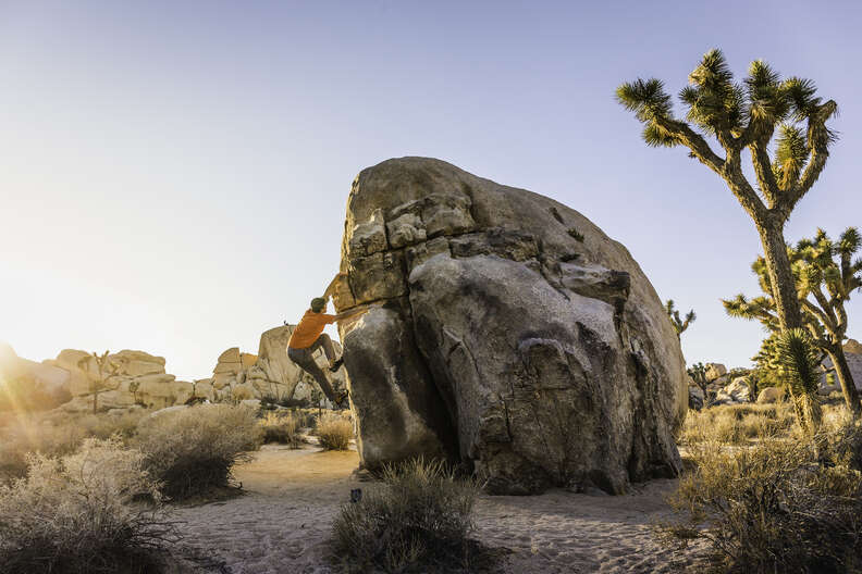 a person climbing a rock in a desert