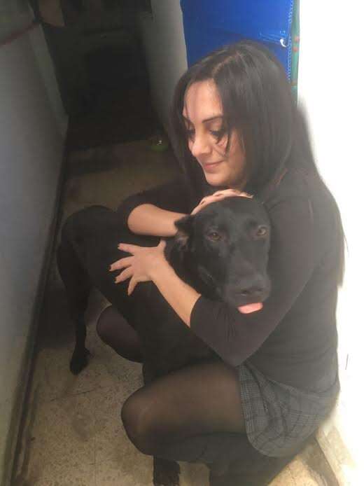 Woman hugging black dog