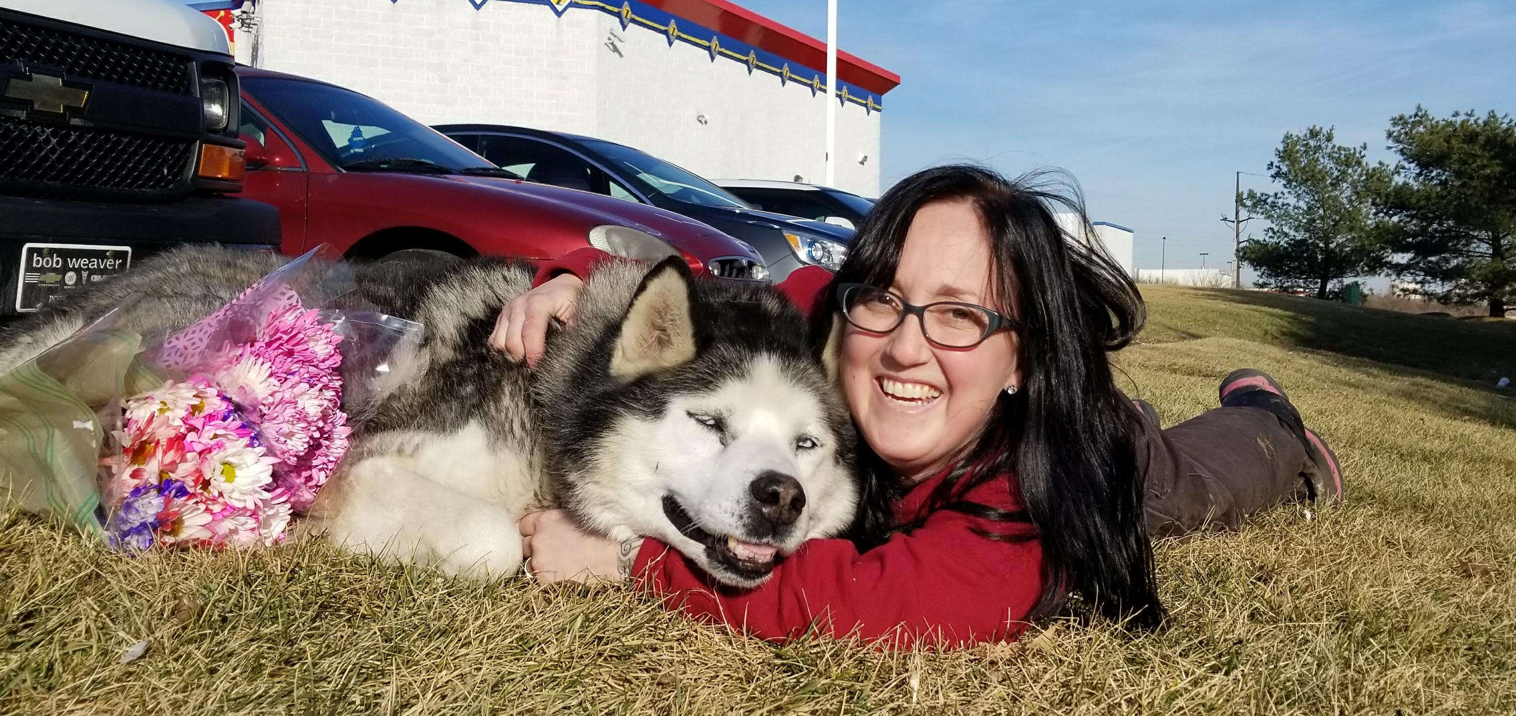 Woman posing with husky on the ground