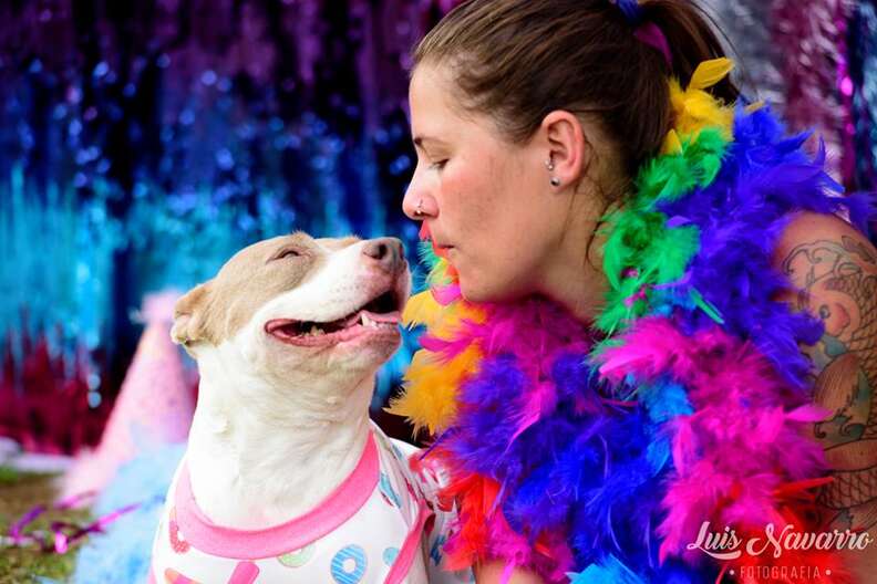 Dressed-up woman posing with smiling puppy