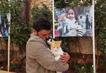 Man holding cats in courtyard