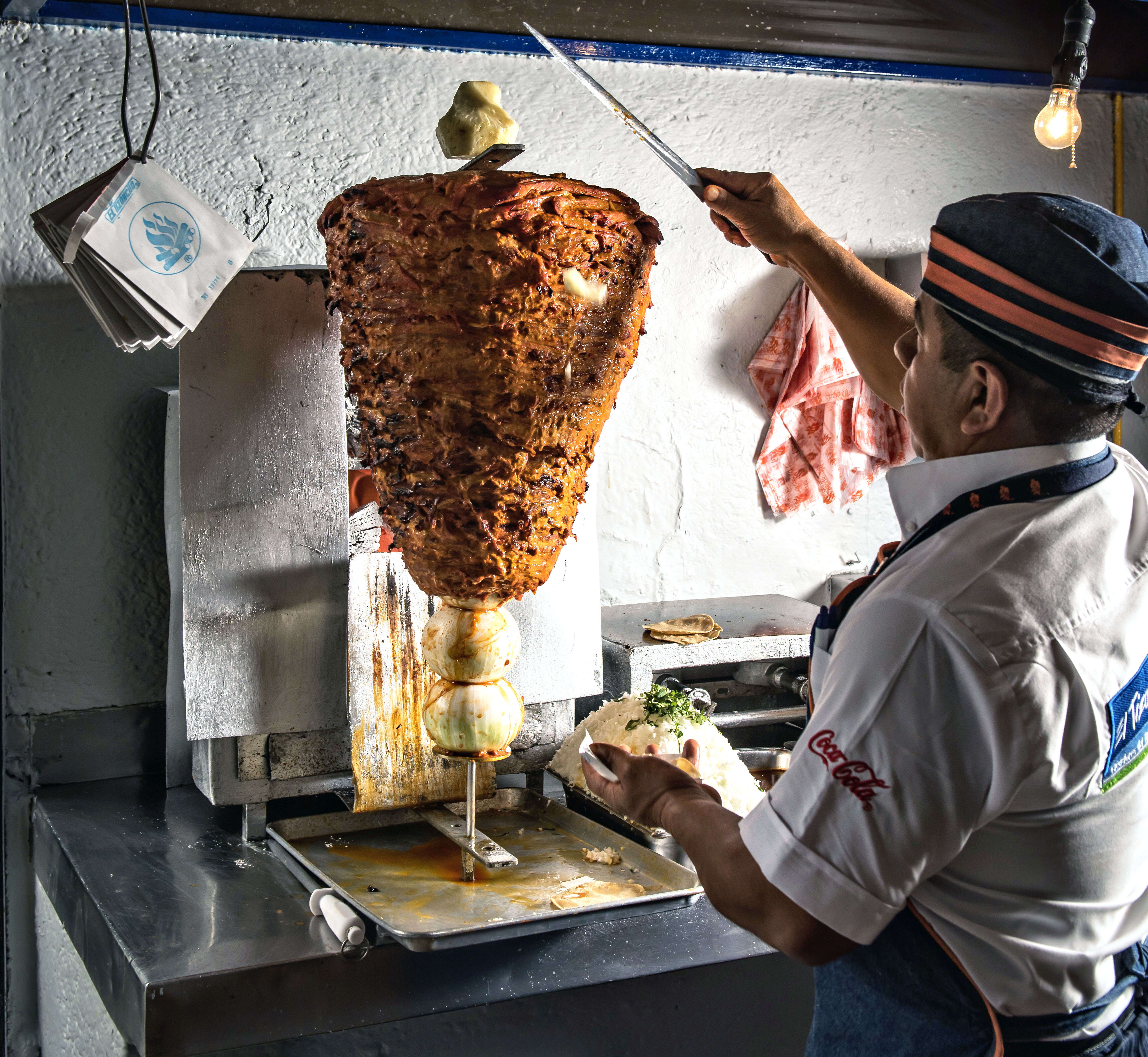 a chef making al pastro tacos in mexico city, mexico
