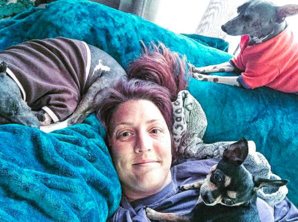 Woman lying on couch with special needs dogs