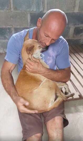 Man cuddling rescue dog in his lap