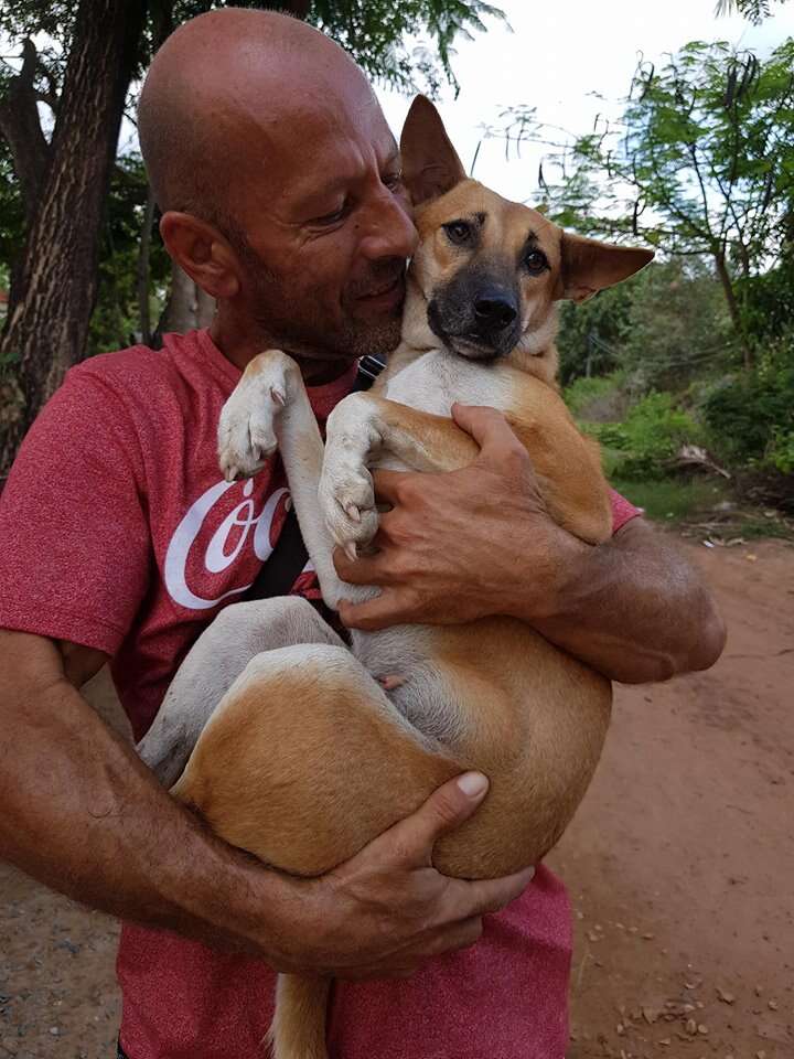 Man holding rescued dog in his arms