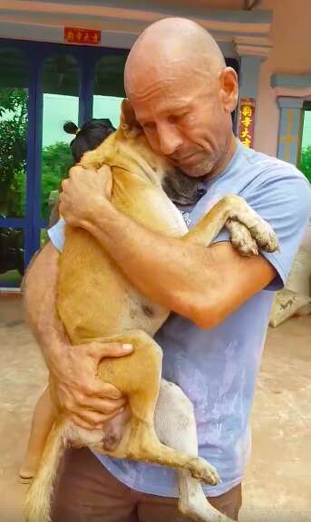 Man holding a dog her just rescued