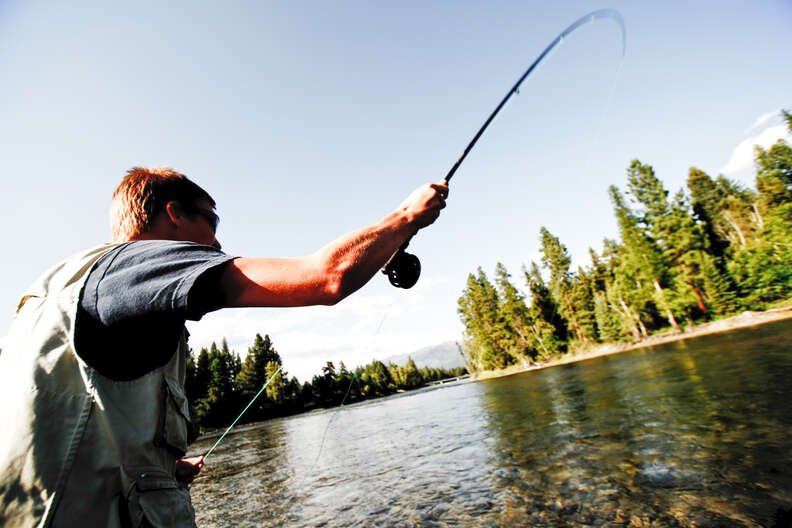 close up of man casting fishing pole in bigfork