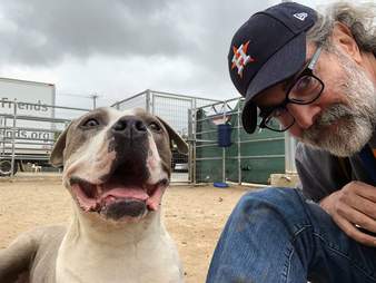 Man sitting next to smiling dog
