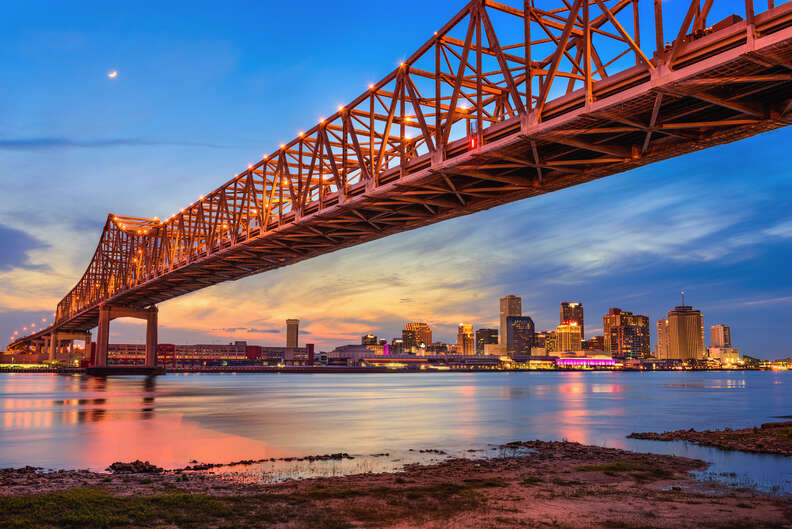 bridge leading over a river past a city