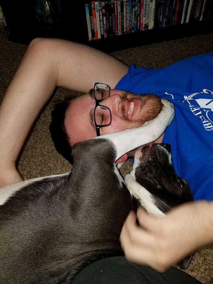 Dog cuddling with man