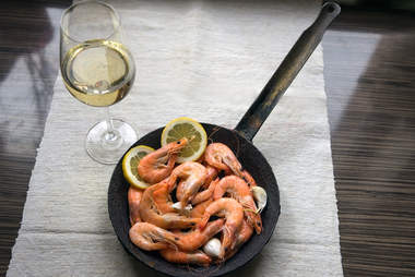 shrimp in a skillet and glass of white wine