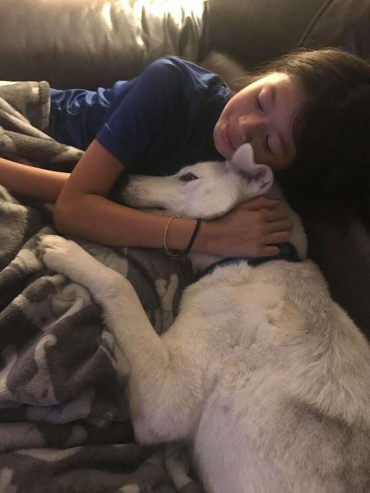 Girl cuddling with dog
