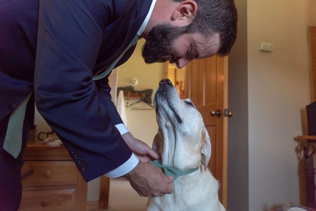 Man touching noses with yellow Labrador retriever