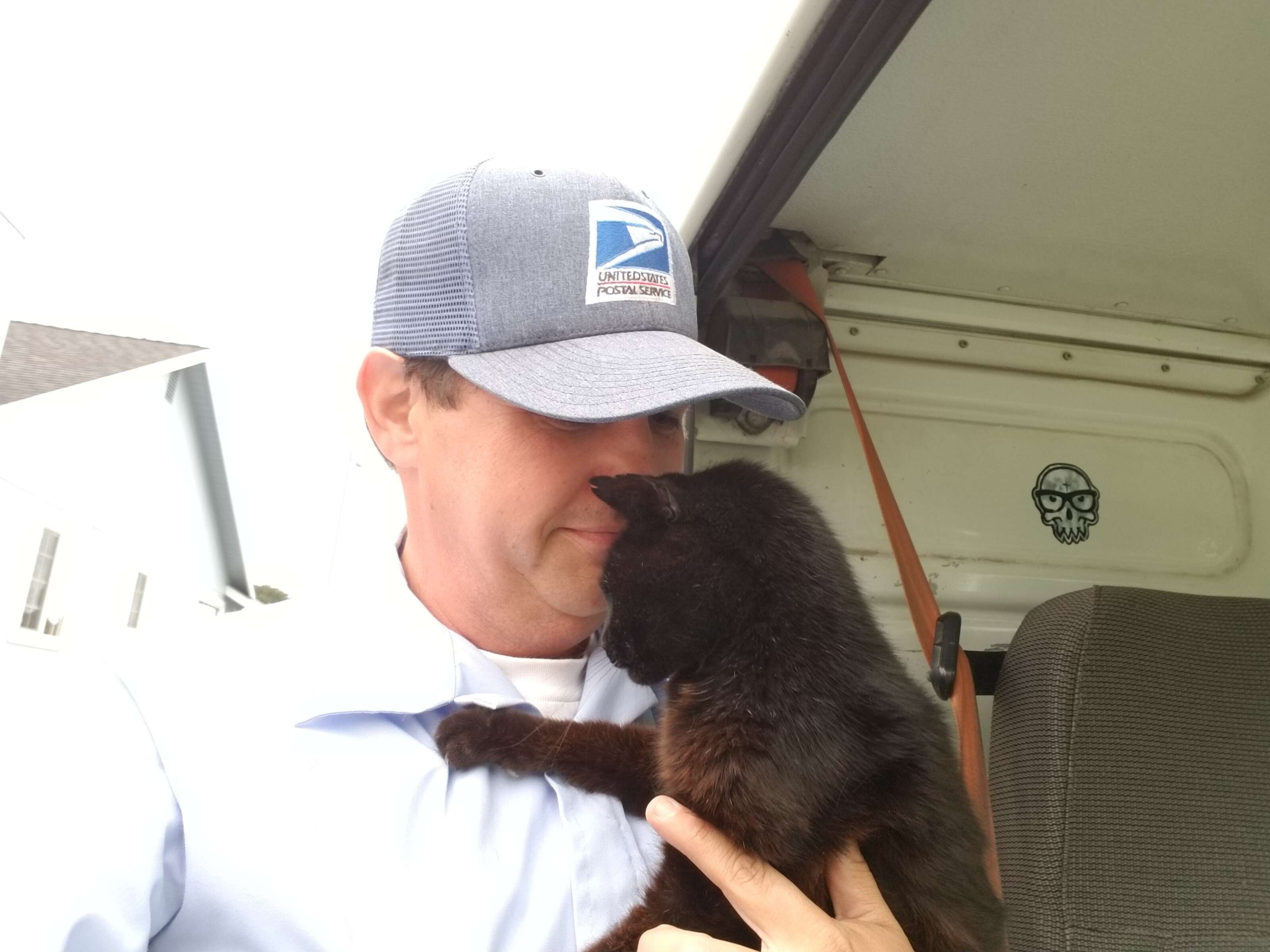 A California mailman snuggles a cat along his route