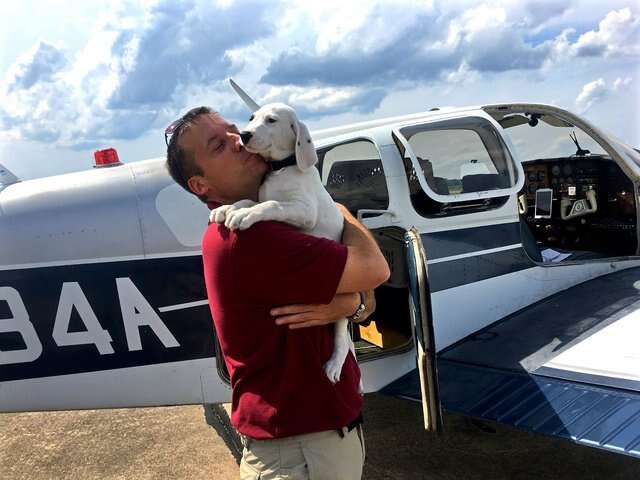 Paul Steklenski poses with a rescue dog and his plane