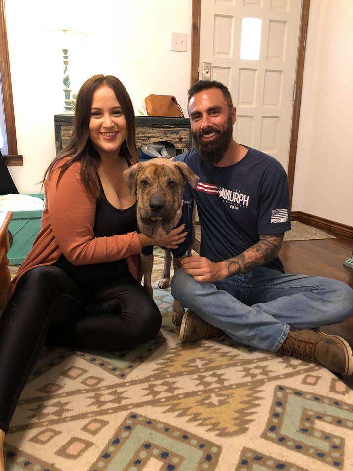 Rescued dog posing with his rescuers