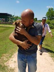 Man cradling rescued dog in his arms