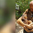 Man cradling dog in his arms