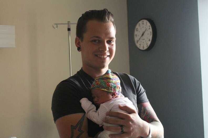 Korey Taphouse holds his newborn daughter