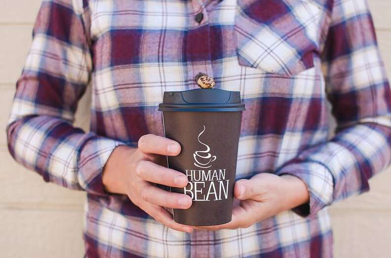 The Human Bean paper coffee cup held