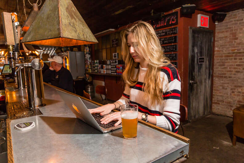 woman working in bar on laptop