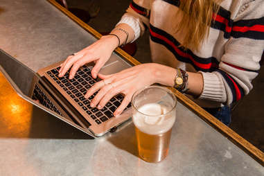 woman working in bar on laptop