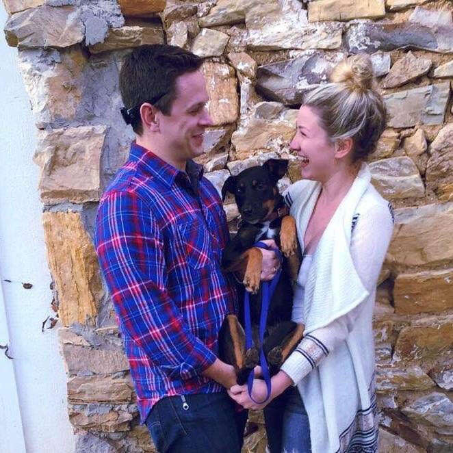 Couple holding dog between them