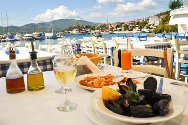 Seafood dinner in a Greece restaurant, Mediterranean sea resort with white wine