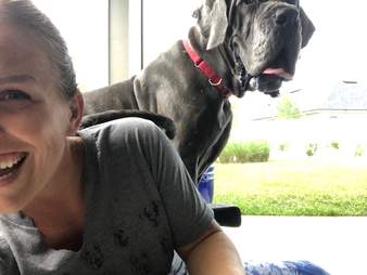 Dog standing behind woman