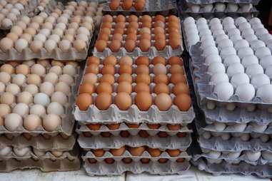 cardboard crates of fresh white, yellow and brown eggs