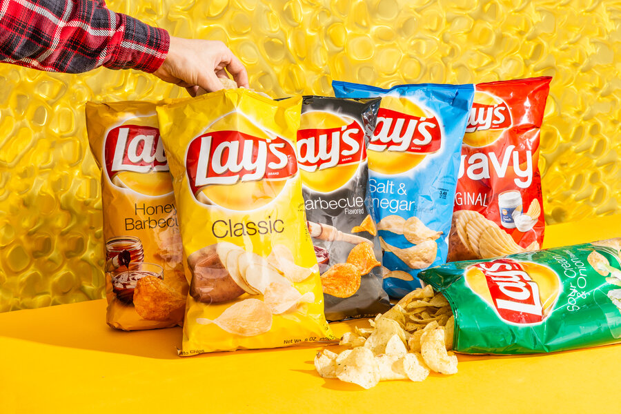 A worker sorts fried crinkle-cut potato chips as they move along a News  Photo - Getty Images