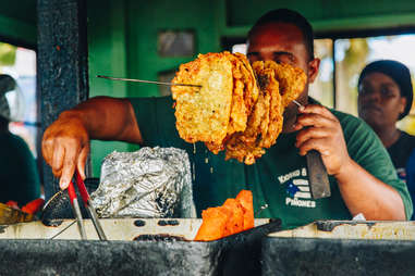 Kiosko El Boricua's massive fritters on a skewer, held by a man