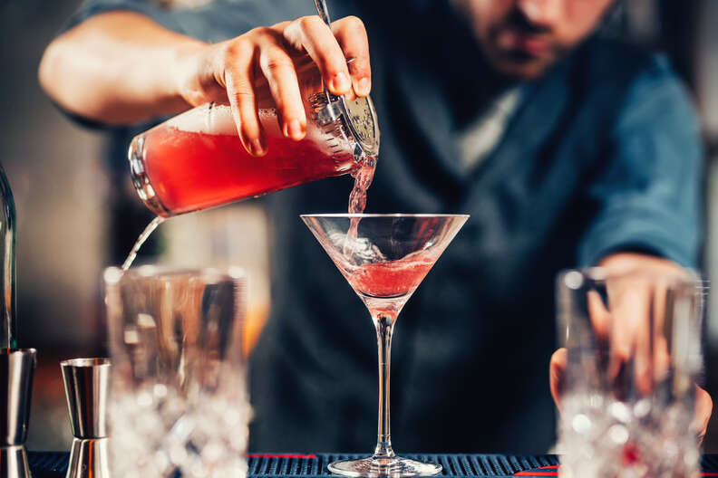 barman pouring cosmopolitan inyo martini glass