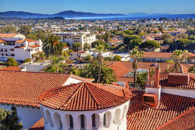 Spanish tile roofs surrounded by palm trees looking out toward the ocean