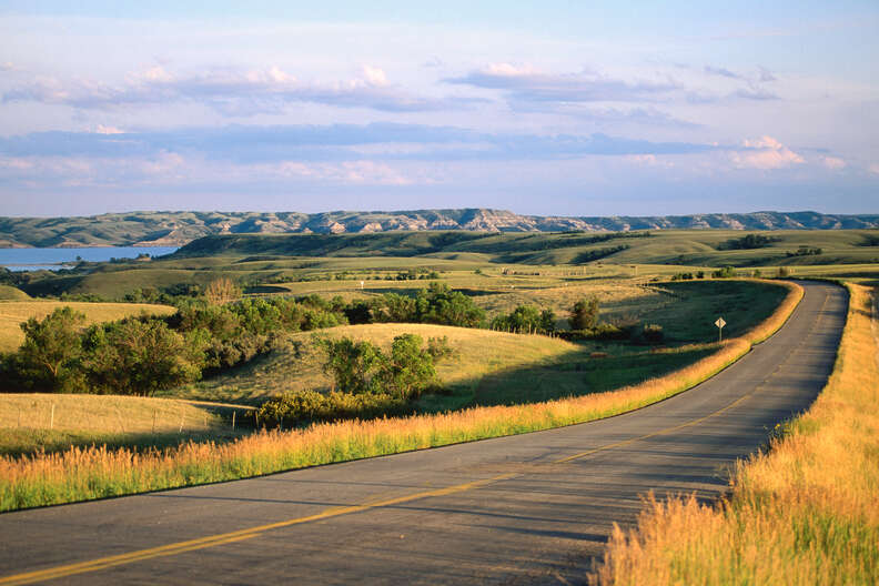 road leading through fields toward badlands