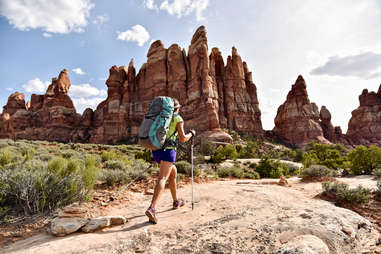 person hiking through a desert with rock spires