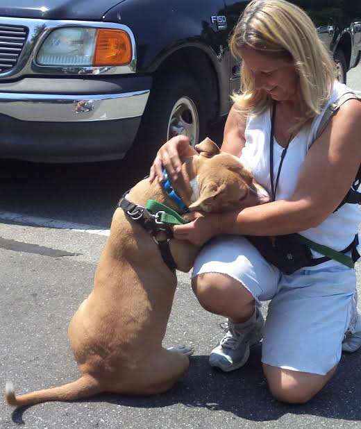 Woman cuddling with leashed dog