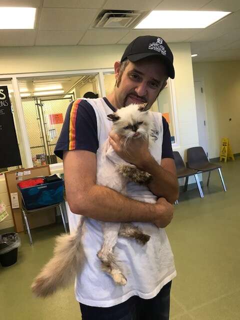 Man holding cat he lost three years ago