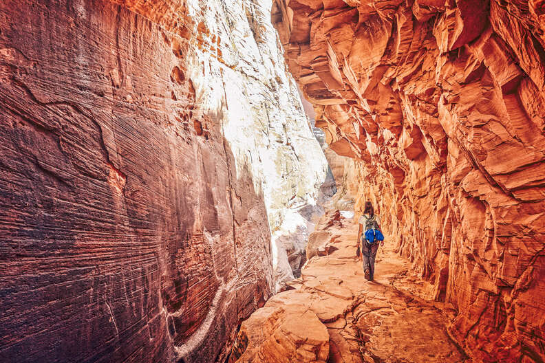 a person walking through a canyon cavern