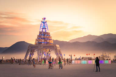 a large, unusual art installation in the desert surrounded by crowds