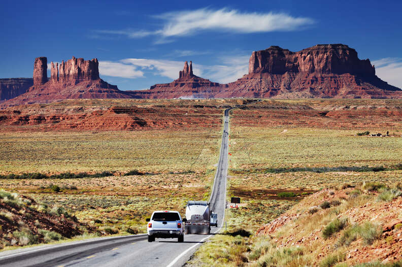 highway headed through enormous stone monuments in the desert