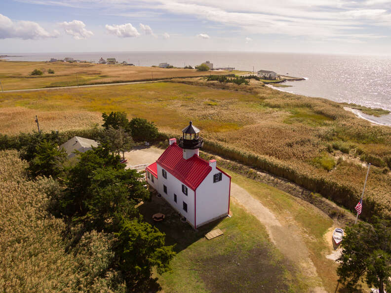 lighthouse on a grassy hill near water