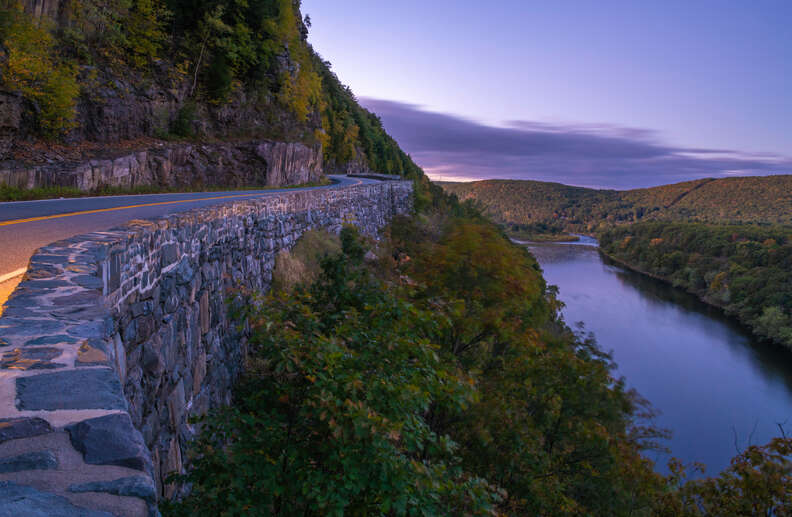 mountainside road winding past a river