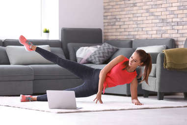 A woman works out in her living room