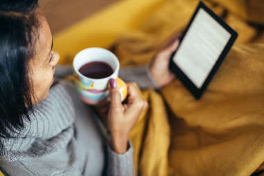 A woman reads on an electronic device 