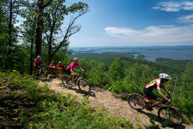 people biking with lake in the background