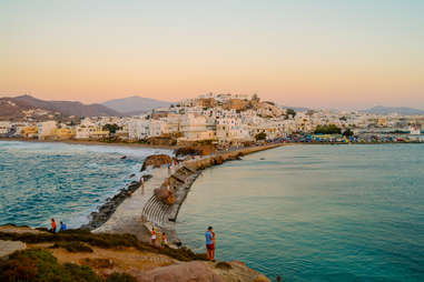 people crossing over natural bridge in naxos, greece