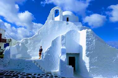 tourist visiting white church in mykonos, greece