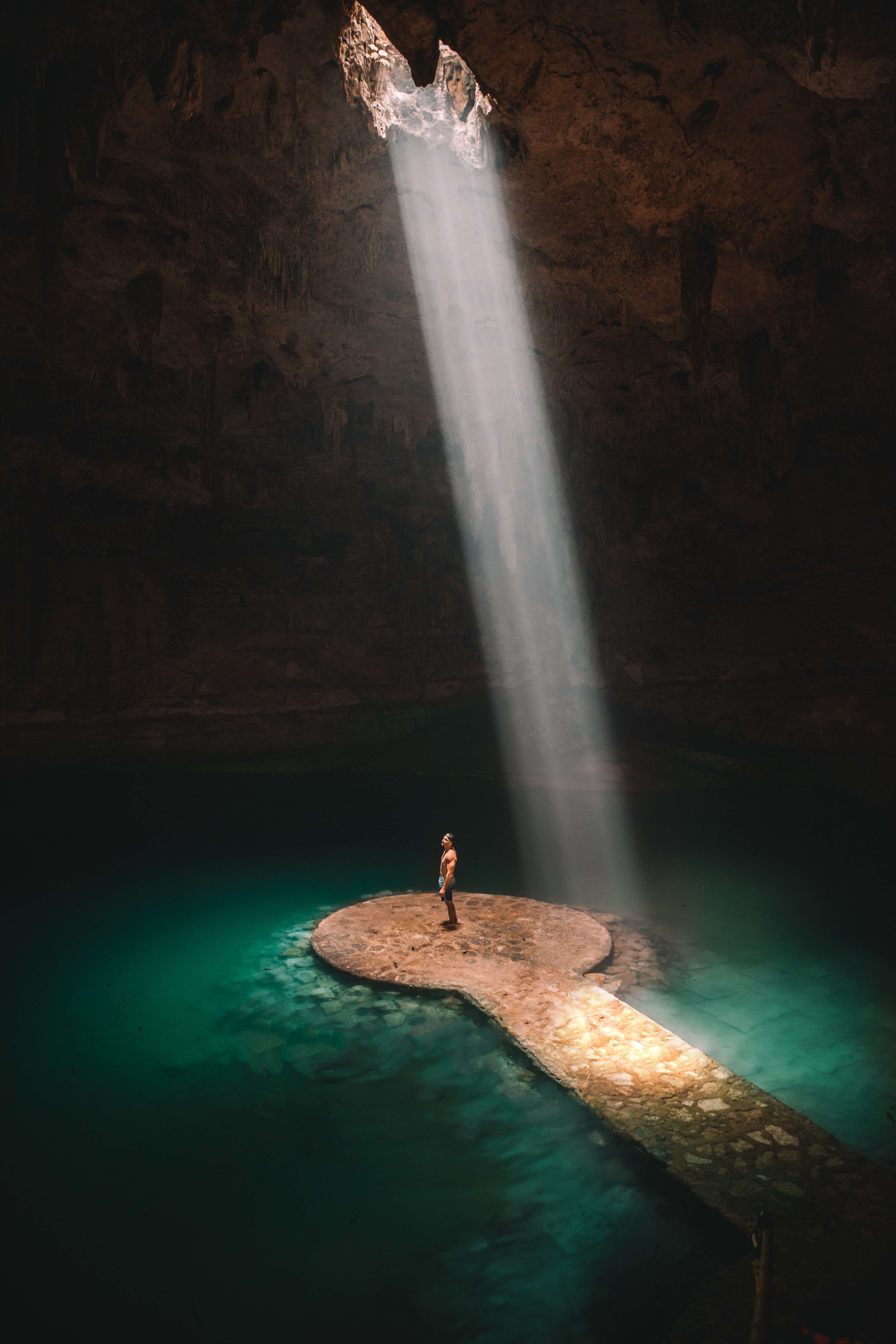 person on a small island in an underground cave